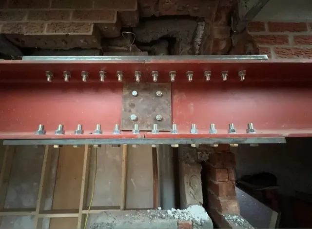 Steel beam bolted in place during load-bearing wall removal