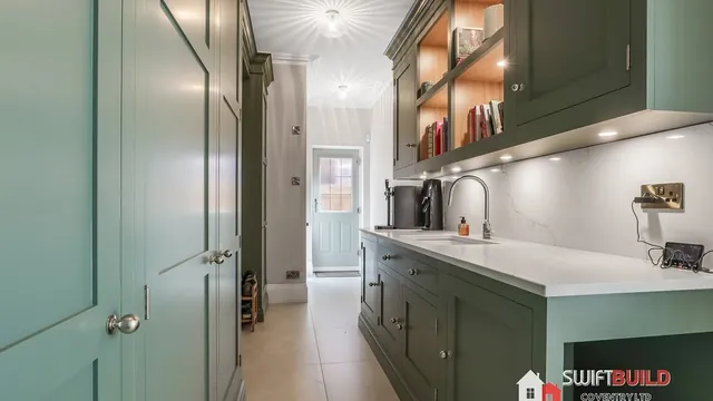 Green utility room refurbishment with fitted cabinets
