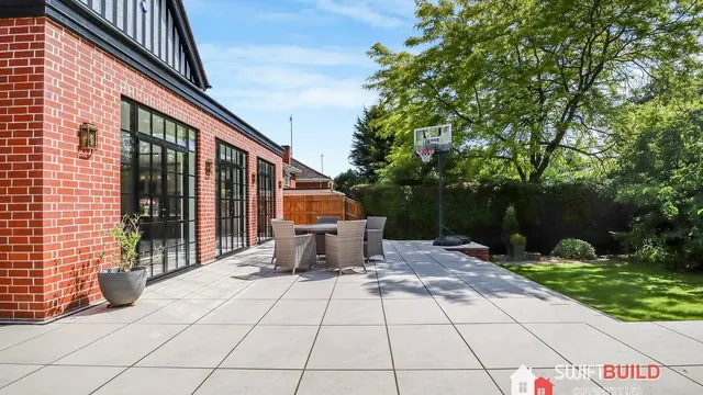 Brick single-storey extension with black-framed glazing and garden patio