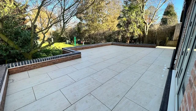 New porcelain patio with brick garden wall and coping